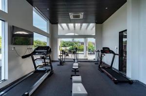 a gym with treadmills and ellipticals in a building at Pillowtalk Apartment in Nerul