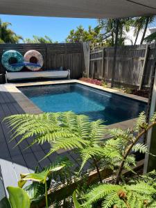 a swimming pool in a backyard with a fence at The Orchard Guesthouse in Palmwoods