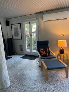a living room with a chair and a lamp at The Orchard Guesthouse in Palmwoods +34 photos