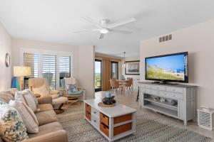 un salon avec un canapé et une télévision à écran plat dans l'établissement Summer Winds C-122, à Indian Beach
