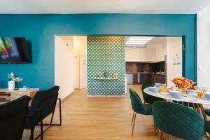 a dining room with blue walls and a table and chairs at Gatsby - Appartement rénové élégant, Hypercentre Saintes, Calme, Fibre, TV 4K, Netflix in Saintes