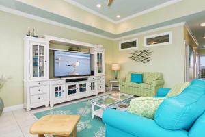 a living room with a blue couch and a tv at Ocean Club J-301 in Indian Beach