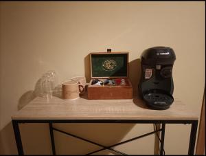 una macchina per il caffè e una scatola su un tavolo con le tazze di Suite parentale avec terrasse solarium a Saint-André-de-Roquelongue