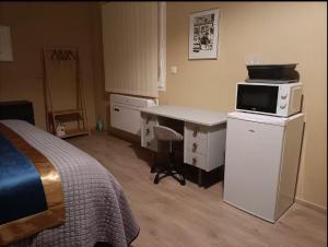una camera con letto e scrivania con forno a microonde di Suite parentale avec terrasse solarium a Saint-André-de-Roquelongue
