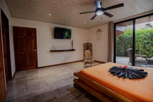 Un dormitorio con una cama y un ventilador de techo. en Samara Chillout Lodge - Adults only, en Sámara