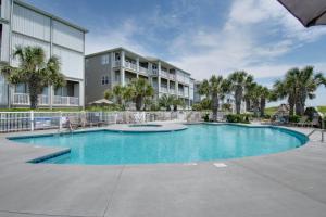 a swimming pool in front of a building at Ocean Club J-301 in Indian Beach