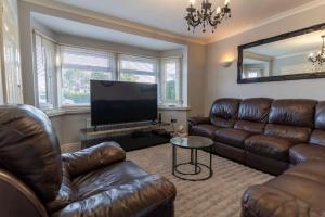 a living room with leather furniture and a flat screen tv at Stunning 4 bed-house in Oxford sleeps 8 in Oxford
