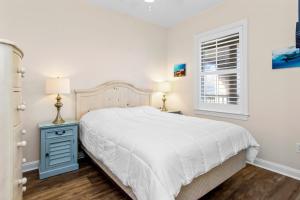 a white bedroom with a bed and a window at Ocean Club E-301 in Indian Beach +48 photos
