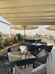 a restaurant with tables and chairs and umbrellas at La Pyramids otel in Cairo