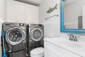 a bathroom with a washing machine and a sink at Nautical Skies in Indian Beach
