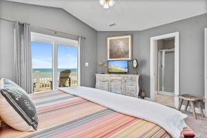 a bedroom with a large bed with a view of the ocean at Loving Life East in Emerald Isle