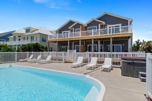 a villa with a swimming pool and a house at Loving Life East in Emerald Isle