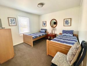 a bedroom with two beds and a mirror at Carolina Clipper West in Emerald Isle