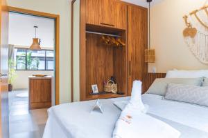 - une chambre avec un lit blanc et un mur en bois dans l'établissement Apê Praia do Toque com Ar no Quarto e Sala, Condomínio com Academia, Quadra de Beach Tennis e Vôlei, Estacionamento Grátis e Restaurante, à São Miguel dos Milagres 29 autres photos