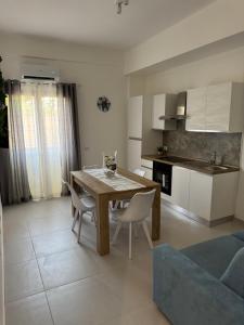 a kitchen and living room with a wooden table and chairs at Sasi Home in Terrasini +10 photos