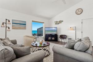 a living room with two couches and a table at Carolina Clipper East in Emerald Isle