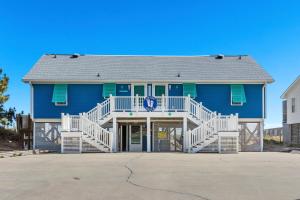 a blue house with white railings on a driveway at Shady Shack West in Emerald Isle