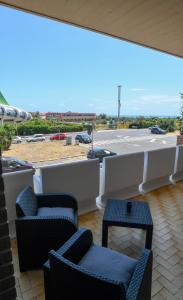 a patio with two chairs and a table and a parking lot at Casetta 48 in Lido di Ostia