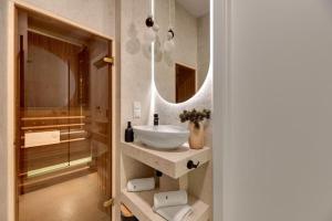 un bagno con lavandino e specchio di Family & Business Sauna Apartments Baltic Horizon No 3 PREMIUM SPA - 3 Bedroom with Private Sauna, Jacuzzi, Rooftop Gym & Panoramic Terrace, Balcony, Underground Garage a Danzica Altre 76 foto