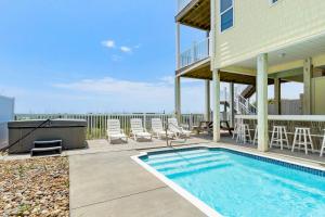 a house with a swimming pool and chairs and a house at Sea La Vie in Indian Beach