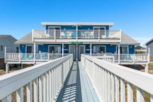 a blue house on a white boardwalk at Shady Shack East in Emerald Isle