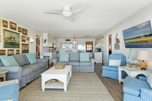 a living room with blue couches and a table at Salty Haven in Emerald Isle