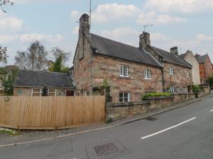 an old brick house with a wooden fence on a street at Ash House in Alton