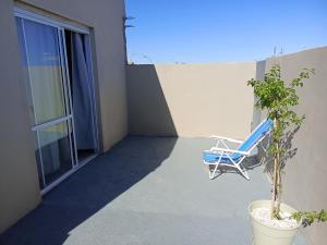 ビージャ・レヒナにあるApart Los Laureles departamento 2の青い椅子と植物のあるバルコニー