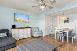a living room with a couch and a table at Pine Knoll Townes 126 by Emerald Isle Realty in Pine Knoll Shores