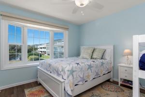 a bedroom with a bed and a window at Pine Knoll Townes 126 by Emerald Isle Realty in Pine Knoll Shores +30 photos