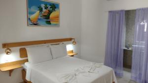 a bedroom with a white bed and a window at Hawaii Flats in São Miguel do Gostoso +76 photos