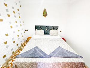 a bedroom with a bed with a quilt on it at Sun Hostel in Marrakech