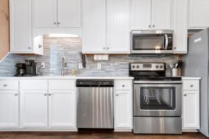 a kitchen with white cabinets and a stove and microwave at Paradise West in Indian Beach