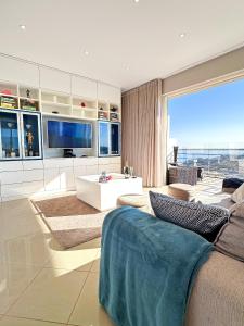 a living room with a couch and a table at Serenity by the Ocean Penthouse by BeCherish in Páteo