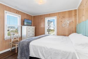 a bedroom with a bed and a desk and a television at Paradise West in Indian Beach
