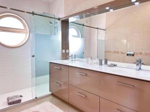 a bathroom with a sink and a glass shower at Serenity by the Ocean Penthouse by BeCherish in Páteo