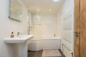 a white bathroom with a sink and a bath tub at Gorlan-Llangwnadl in Llangwnadl +22 photos