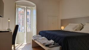 een slaapkamer met een bed met een blauwe sprei en een raam bij Antica Dimora Petito Luxury Suites in Matera