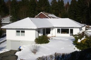 una casa bianca con neve sul vialetto di Ferienhaus Sonnenwinkel a Braunlage