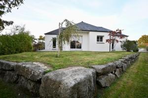 a stone retaining wall in front of a house at Maison moderne avec spa et jardin sans vis-à-vis, idéal professionnels et familles - L'ÉCRIN BRETON in Vannes
