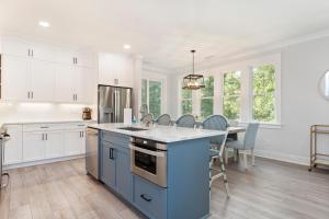 a kitchen with a blue island and a table with chairs at Afterdune Delight in Cedar Point