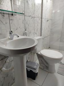 Un baño blanco con lavabo e inodoro. en Hotel Macapá, en Macapá 14 fotos más