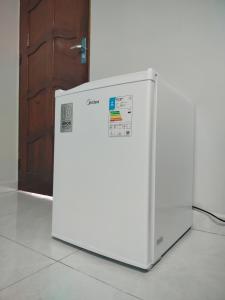 马卡帕Hotel Macapá的一台白色冰箱摆放在一扇门前