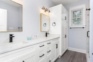 a white bathroom with two sinks and a mirror at Afterdune Delight in Cedar Point +76 photos