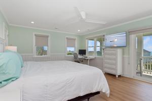a bedroom with a bed and a tv and a desk at A Lil Salt n Lime in Bogue