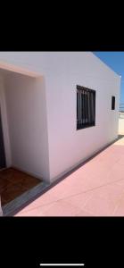 una pared blanca con una ventana con barrotes negros en Appartement calme et lumineux, en Sousse