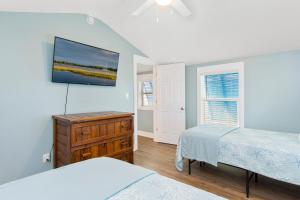 a bedroom with two beds and a television on the wall at C-Life in Emerald Isle