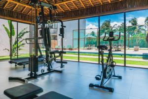 une salle de sport avec des tapis roulants et des appareils d'exercice dans un bâtiment dans l'établissement Apê Praia do Toque com Ar no Quarto e Sala, Condomínio com Academia, Quadra de Beach Tennis e Vôlei, Estacionamento Grátis e Restaurante, à São Miguel dos Milagres