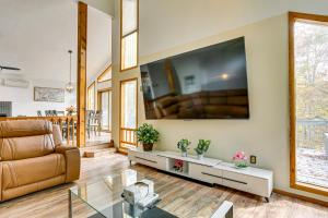 a living room with a couch and a large screen tv at Luxury Home with Game Room, 4 Mi to Bushkill Falls! in Saw Creek