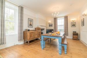 un comedor con una mesa azul y algunas ventanas en Rheithordy, en Trawsfynydd